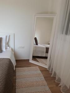 a bedroom with a mirror and a bed and a rug at Apartment Laoura in Corfu Town