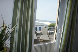 a sliding glass door with chairs on a balcony at Ferienwohnung Störtebekersuite in Glowe