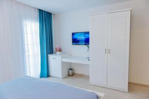 a bedroom with a bed and a desk and a tv at Via Farilya Hotel in Gundogan