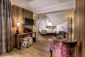 a hotel room with a bed and a living room at Hotel Brigitte in Ischgl