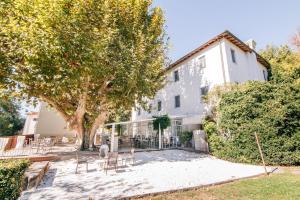 un bâtiment avec des chaises et un arbre devant lui dans l'établissement Villa La Bianca, à Camaiore