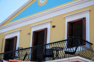 a balcony with a clock on the side of a building at Korali in Symi