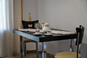 a black table with cups and saucers on it at Korali in Symi