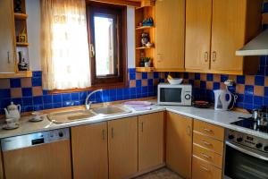 a kitchen with wooden cabinets and a sink and a microwave at Korali in Symi +37 photos