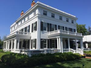 a large white house with a porch at Topping Rose House in Bridgehampton