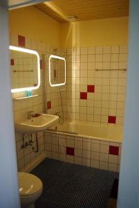 een badkamer met een wastafel, een bad en een toilet bij Alte Schule Osteroden in Merzen