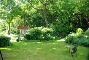 een tuin met twee stoelen en een tafel in het gras bij Alte Schule Osteroden in Merzen