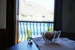 a glass bowl on a table next to a window at Korali in Symi