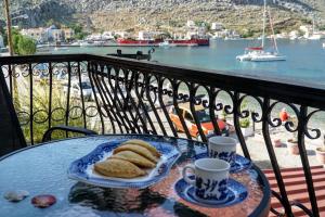 a table with bread and two cups of coffee on a balcony at Korali in Symi