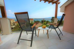 2 Stühle und ein Tisch auf dem Balkon in der Unterkunft Vila La ViTa del Mare in Bijela