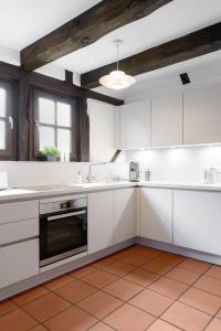 cocina con armarios blancos y techo en Moderne trifft auf Fachwerk, en Wedemark