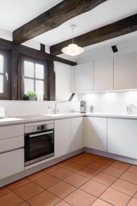 a kitchen with white cabinets and a ceiling at Moderne trifft auf Fachwerk in Wedemark +6 photos