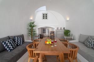 a living room with a wooden table with a bowl of fruit at Radiant Santorini in Mesaria