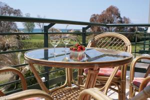 a table with two glasses of wine and a bowl of fruit at Oxana house in Nea Moudania