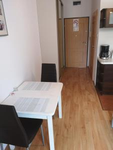 a white table and chairs in a room with a kitchen at Apartament Trzy Korony 1 in Świnoujście