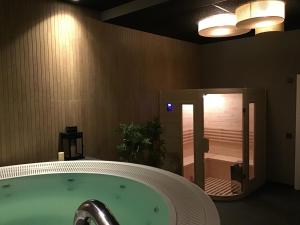 a bath tub in a bathroom with a shower at VISTALEGRE Hotel-Spa in Portomarin