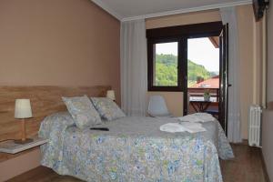 a bedroom with a bed and a window with a view at Pension Reconquista in Cangas de Onís