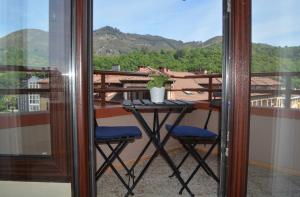 a table and two chairs on a balcony with a view at Pension Reconquista in Cangas de Onís