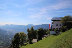 a house with a solar roof on a hill at Gasthof Walde in Rifiano