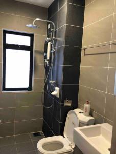 a bathroom with a toilet and a window at Hyve Soho Family Resort Suites in Cyberjaya