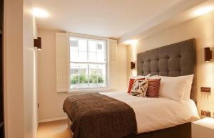 um quarto com uma cama grande e uma janela em Wigmore Suites Serviced Apartments by Globe Apartments em Londres