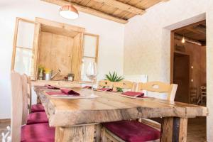 a wooden table with purple chairs and a wooden tableablish at Locanda Ponte Serra in Lamon