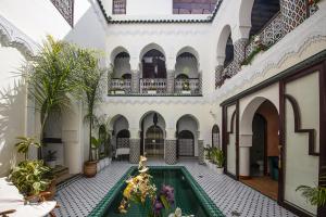 un patio interior con piscina en un edificio en Riad Maison Belbaraka, en Marrakech