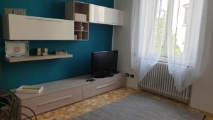 salon z telewizorem na stojaku z oknem w obiekcie cesena3 plus w Mediolanie