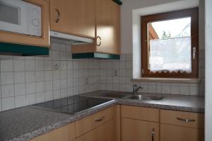 cocina con fregadero y ventana en Pension Pichler, en Leutasch