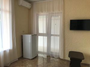 ヴァルダネにあるAtlantidaの冷蔵庫、窓、テレビが備わる客室です。