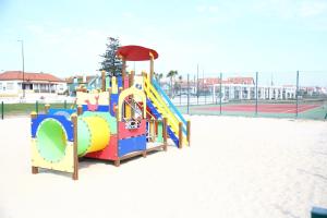 a playground with a slide in the sand at Salinas Beach House - T3 Apartment - Costa Nova in Costa Nova