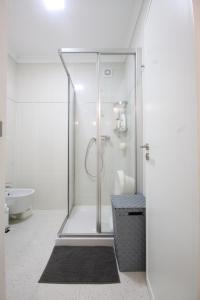uma casa de banho branca com um chuveiro e um lavatório. em Salinas Beach House - T3 Apartment - Costa Nova em Costa Nova