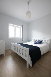 una camera da letto bianca con un letto bianco e una finestra di Salinas Beach House - T3 Apartment - Costa Nova a Costa Nova