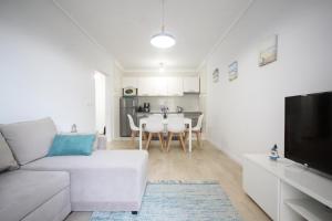 a living room with a white couch and a table at Salinas Beach House - T3 Apartment - Costa Nova in Costa Nova