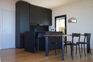 a kitchen with black cabinets and a table and chairs at Villa Crassula in Casarza Ligure