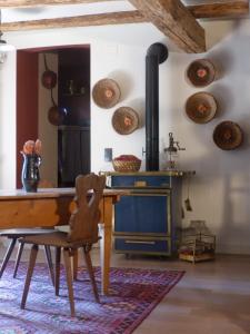 a kitchen with a wooden table and a wood stove at Le voyage d'UBUNTU in Heiligenstein