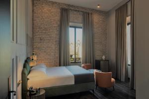 a bedroom with a bed and a brick wall at Chapter Roma in Rome