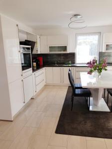 a kitchen with white cabinets and a white table with chairs at Fewo II Familie Sobierajczyk in Blankenhagen