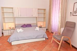 a bedroom with a bed with two pillows and a chair at Garibaldi B&B in Cefalù