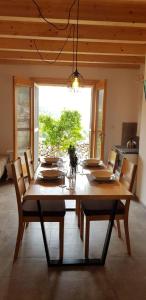 a dining room table with chairs and a large window at Villa Duboka, Otok Vis in Komiža