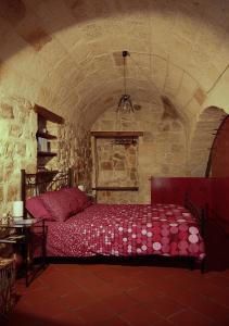 een slaapkamer met een bed in een stenen kamer bij Casa Vacanze Vico Farinella in Polignano a Mare