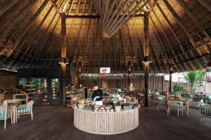 a restaurant with a large ceiling with tables and chairs at Phi Phi CoCo Beach Resort in Phi Phi Islands