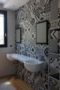 a bathroom with a white sink and a black and white wall at Villa Crassula in Casarza Ligure +23 photos