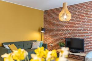 a living room with a couch and a brick wall at Appartementen Zeerust in De Koog
