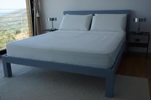 a bed with white sheets and pillows in a bedroom at Villa Crassula in Casarza Ligure