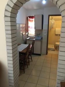 eine Küche mit einem Tisch und Stühlen im Zimmer in der Unterkunft Vila Regina in Palić