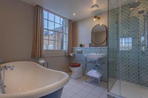 a bathroom with a tub and a sink and a mirror at Richmond Hill Hotel in Richmond upon Thames