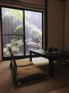 salon ze stołem i dużym oknem w obiekcie FUUTEI Japanese-style lodge w mieście Kioto