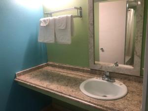 a bathroom with a sink and a mirror and towels at Seminole Inn in Donalsonville +30 photos