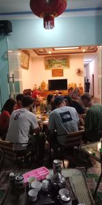 un grupo de personas sentadas en una mesa en una habitación en Lung Ho motel, en Làng Cac